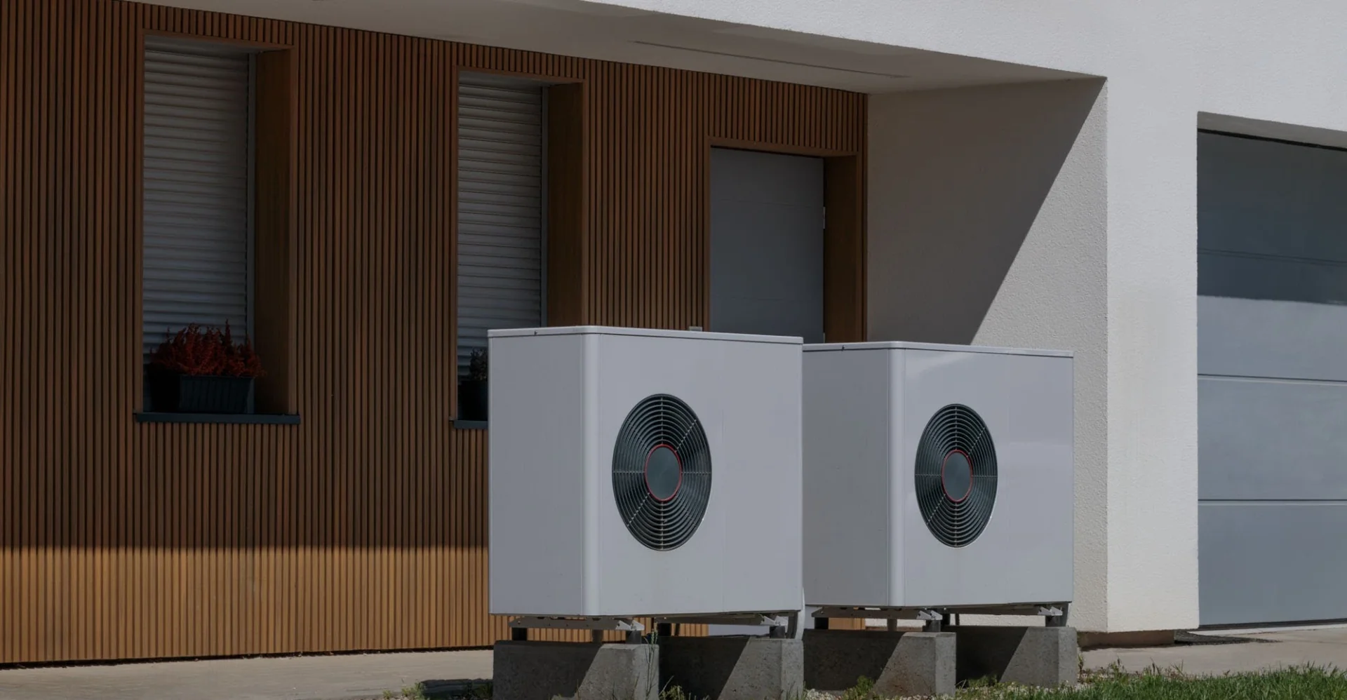 Moderne Wärmepumpen-Außeneinheiten vor Wohnhaus